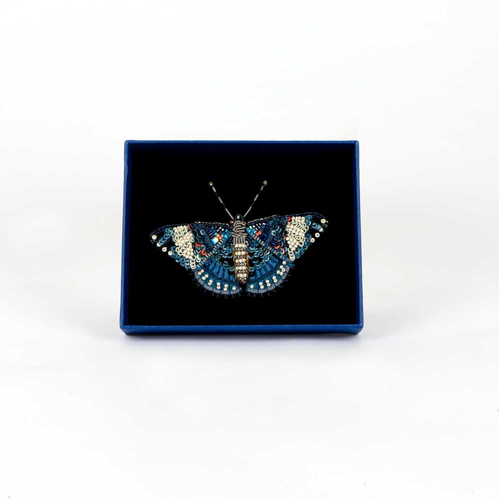 Trovelore Beaded nature brooch hand made in india on white background. Blue Calico Cracker Butterfly