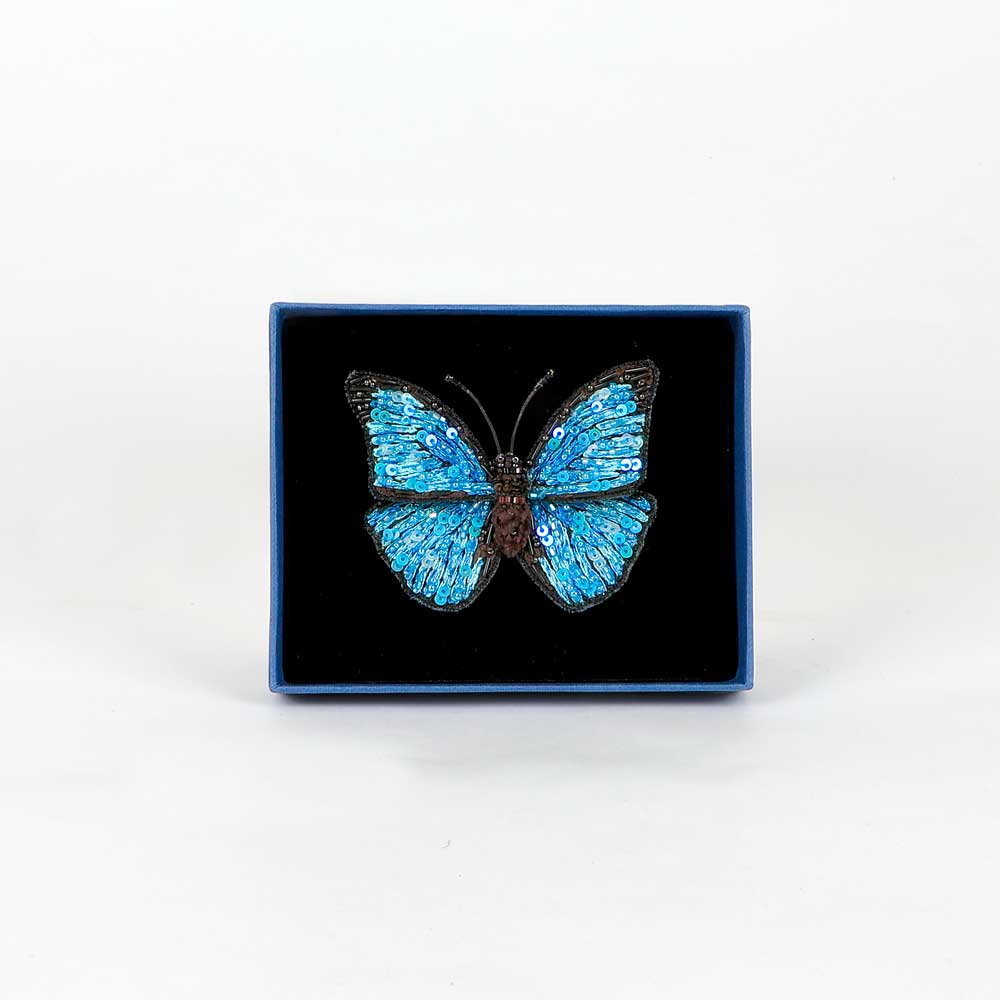 Trovelore Beaded nature brooch hand made in india on white background. Blue Morpho butterfly