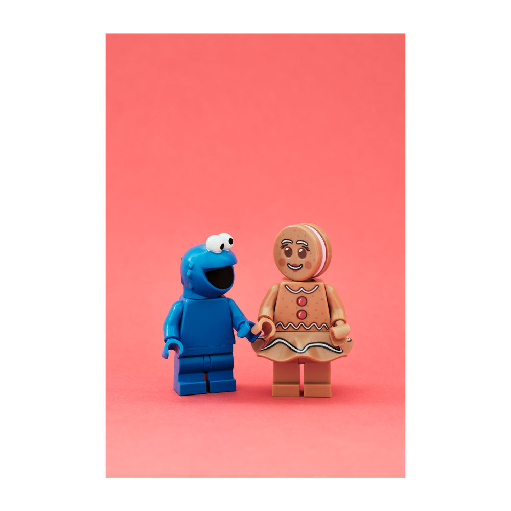 Two LEGO figures, cooke monster and cookie cutie, on a pink background, Adam Popovic photographic print for Relics Exhibition