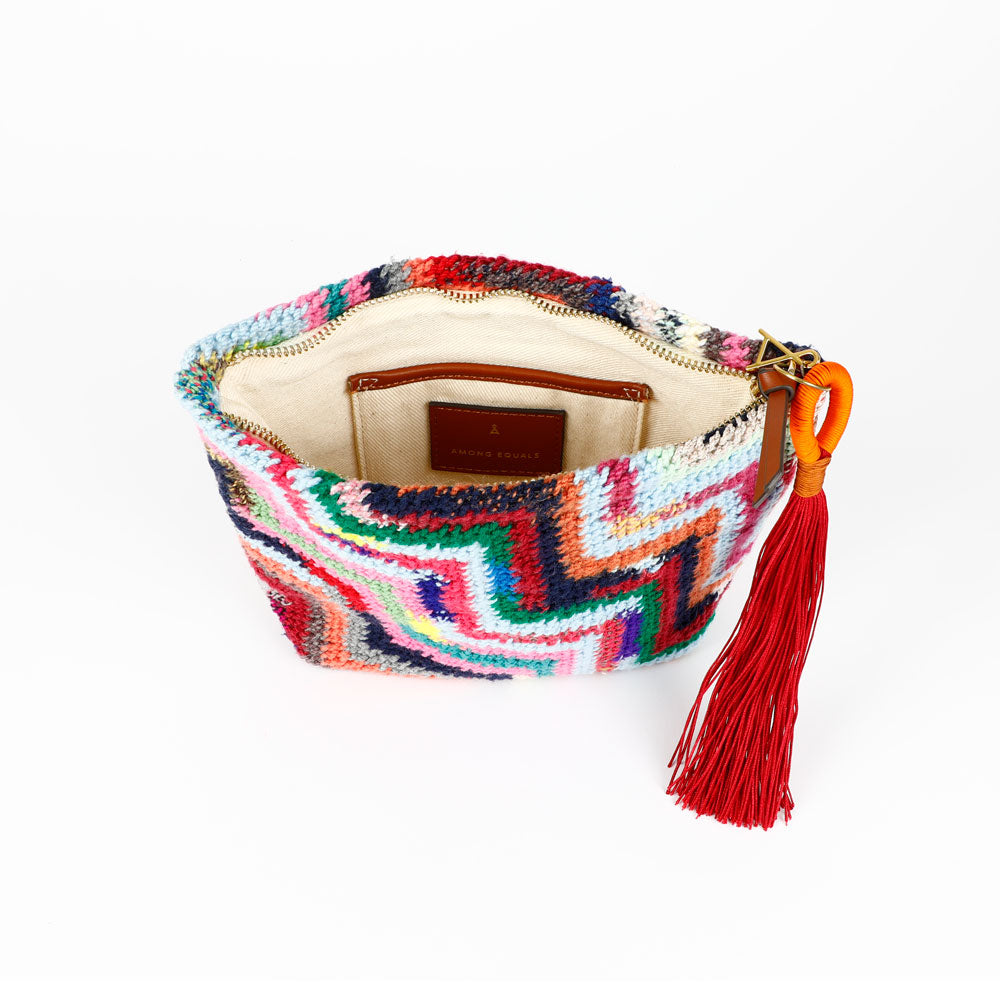 Colorful Florence Steps hand woven Bilum bag with geometric pattern, zip closure and orange and burgundy tassel, interior view, on a white background