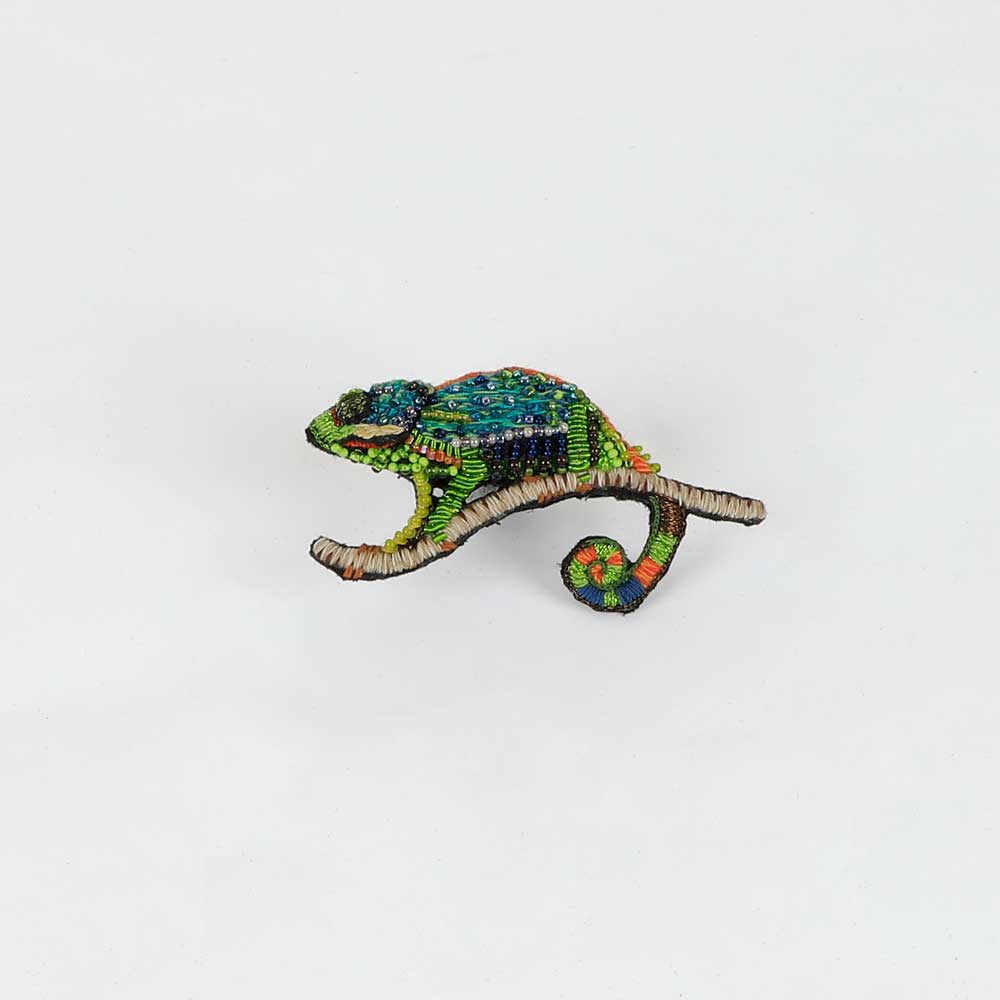 Beaded nature brooch hand made in india on white background. Green chameleon brooch