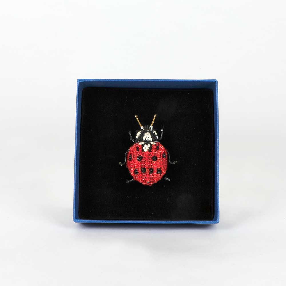 Trovelore Beaded nature brooch hand made in india on white background. Lady Bird Beetle