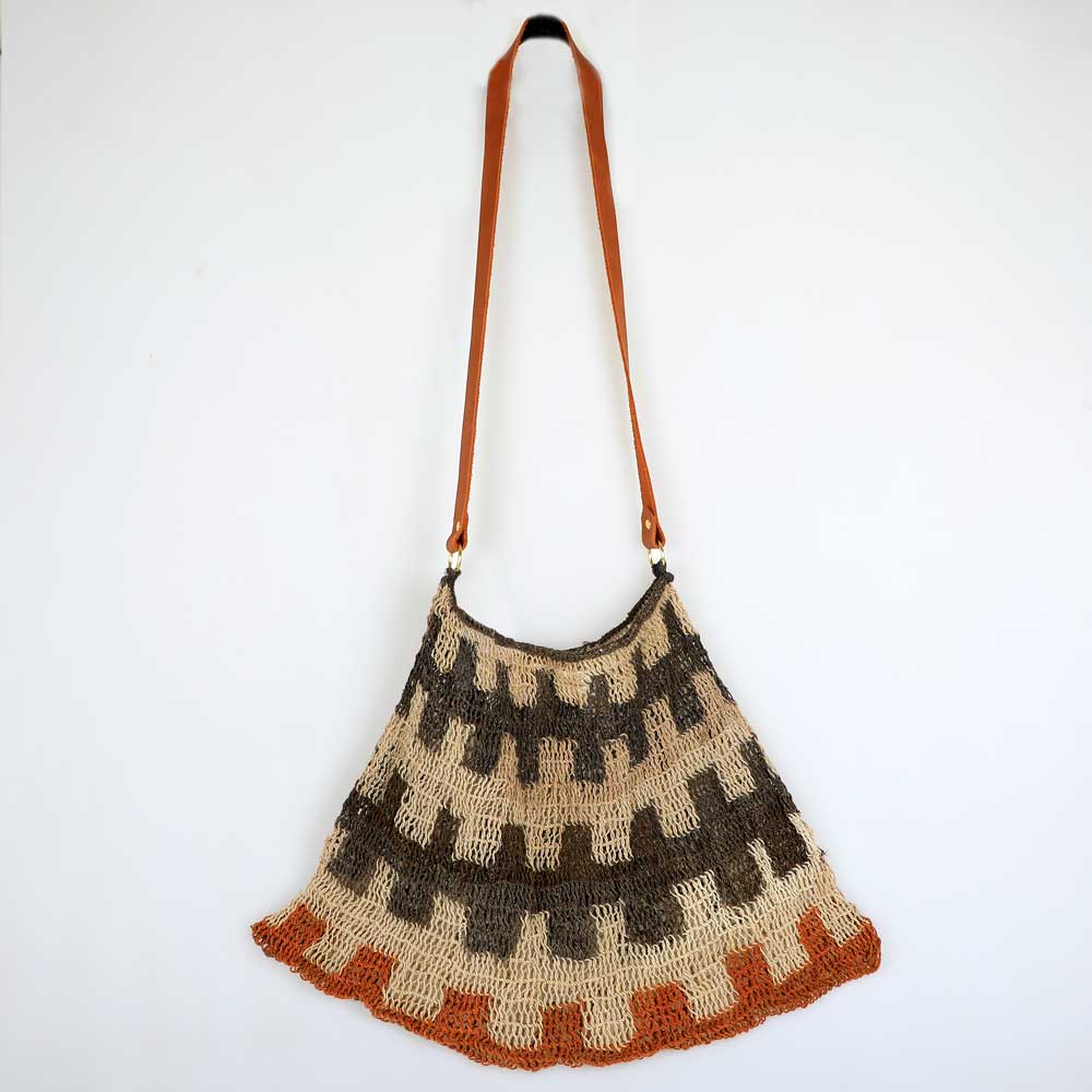 Handwoven natural fibre bilum bag from Papua New Guinea, leather strap. Photographed on white background