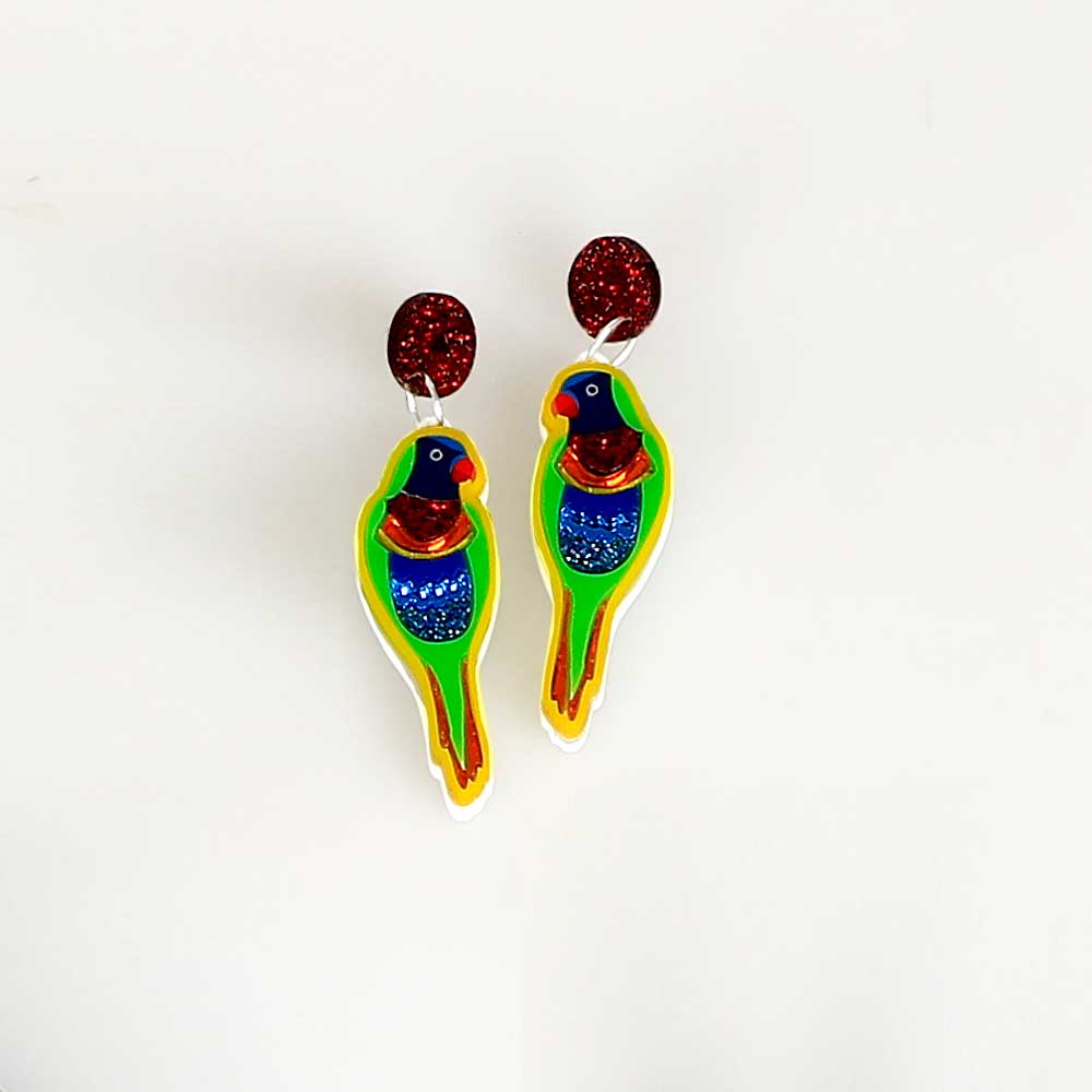 Lorikeet dented diva earrings. Acrylic lorikeet hangs from red sparkle disc ear stud. Photographed on white background for Australian Museum Shop online