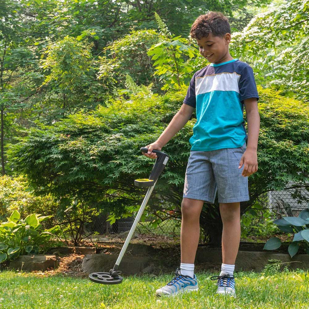 Science in action metal detector in use by young boy in garden