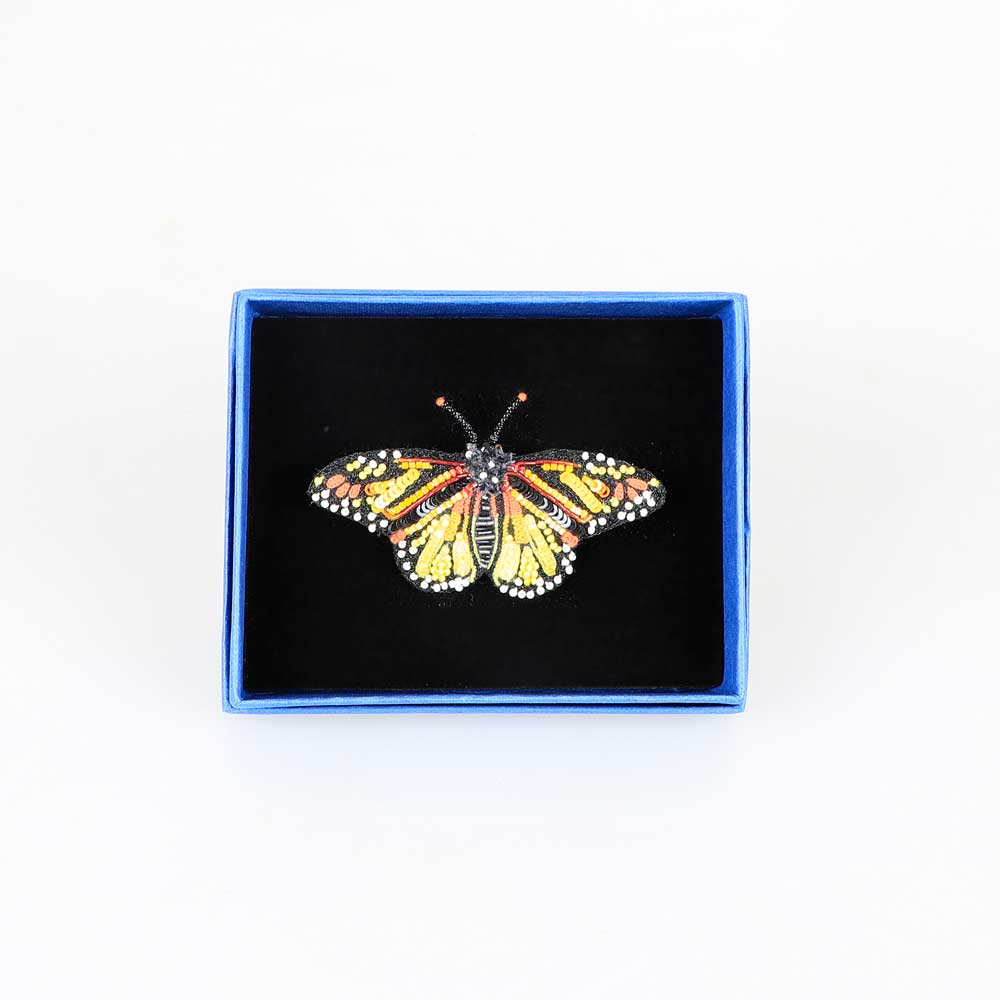 Trovelore Beaded nature brooch hand made in india on white background. Monarch butterfly