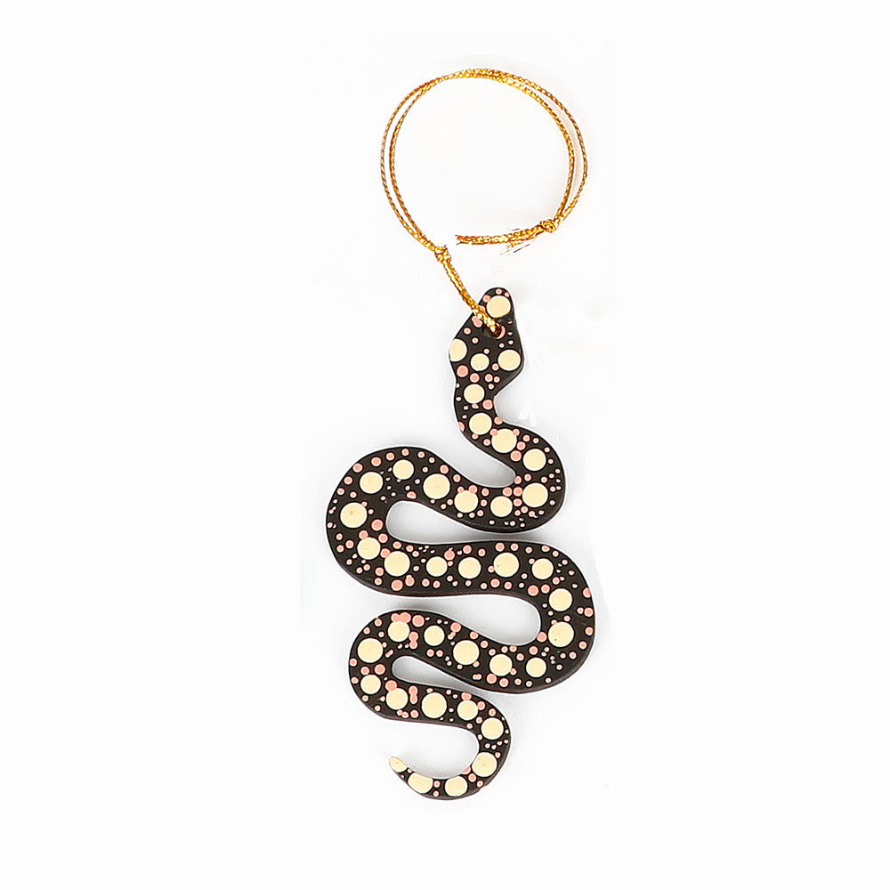 Decorative snake ornament handpainted by Warlukurlangu Artists, on a white background