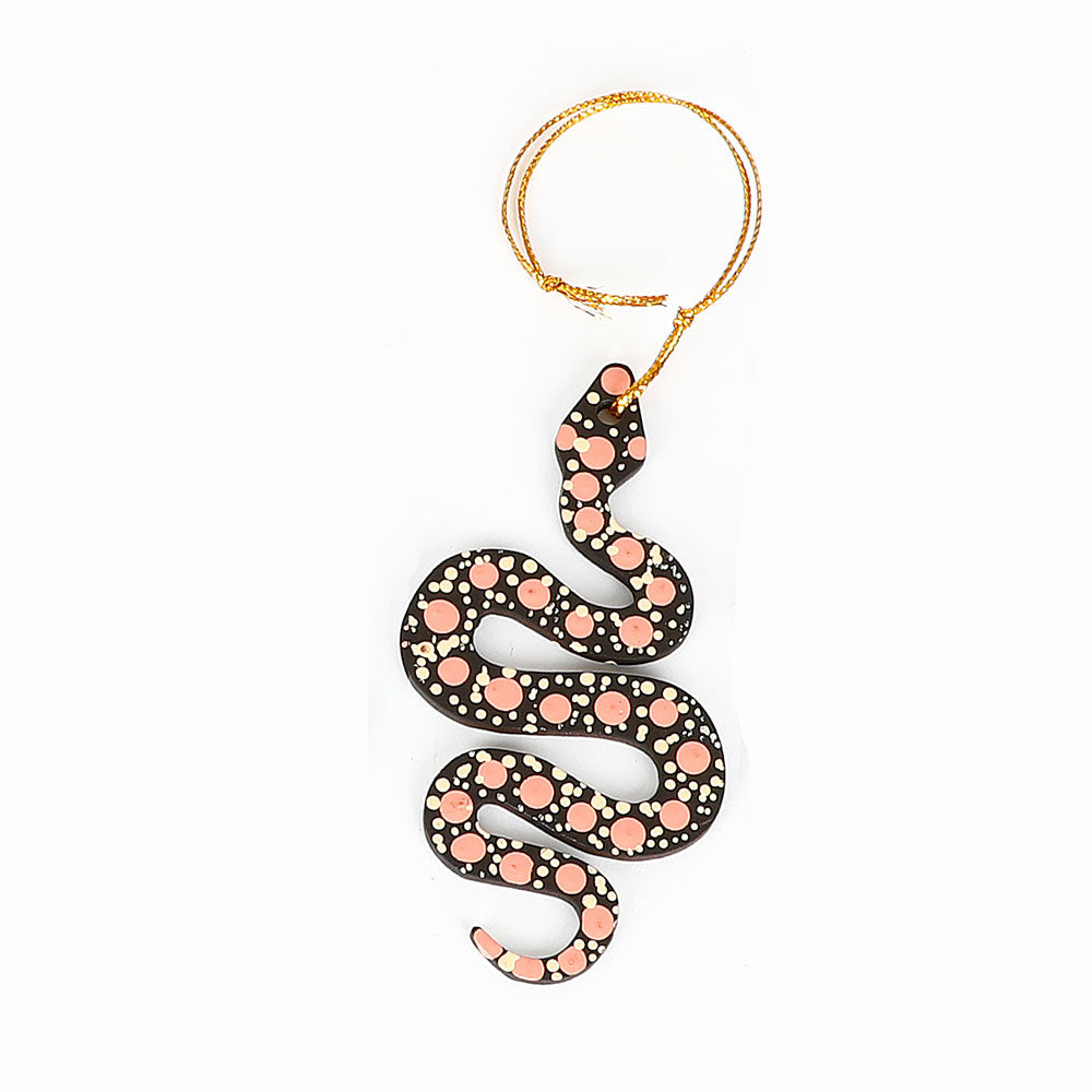 Decorative snake ornament handpainted by Warlukurlangu Artists, on a white background