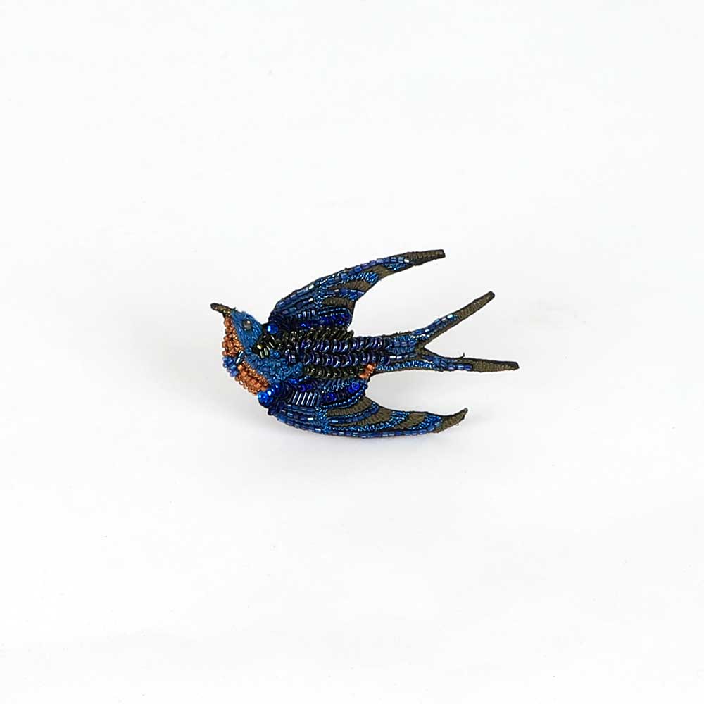 Beaded nature brooch hand made in india on white background. Singing swallow brooch