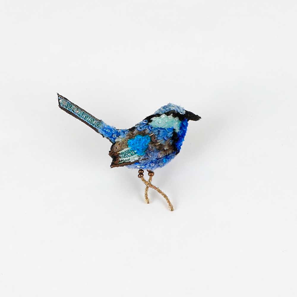 Beaded nature brooch hand made in india on white background. Splendid fairy wren brooch