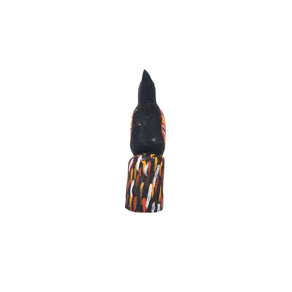 Black Magpie figure, hand carved and painted in the traditional Tiwi Island style, using locally sourced hardwood timber, by artist Albertus Tipiloura on white background