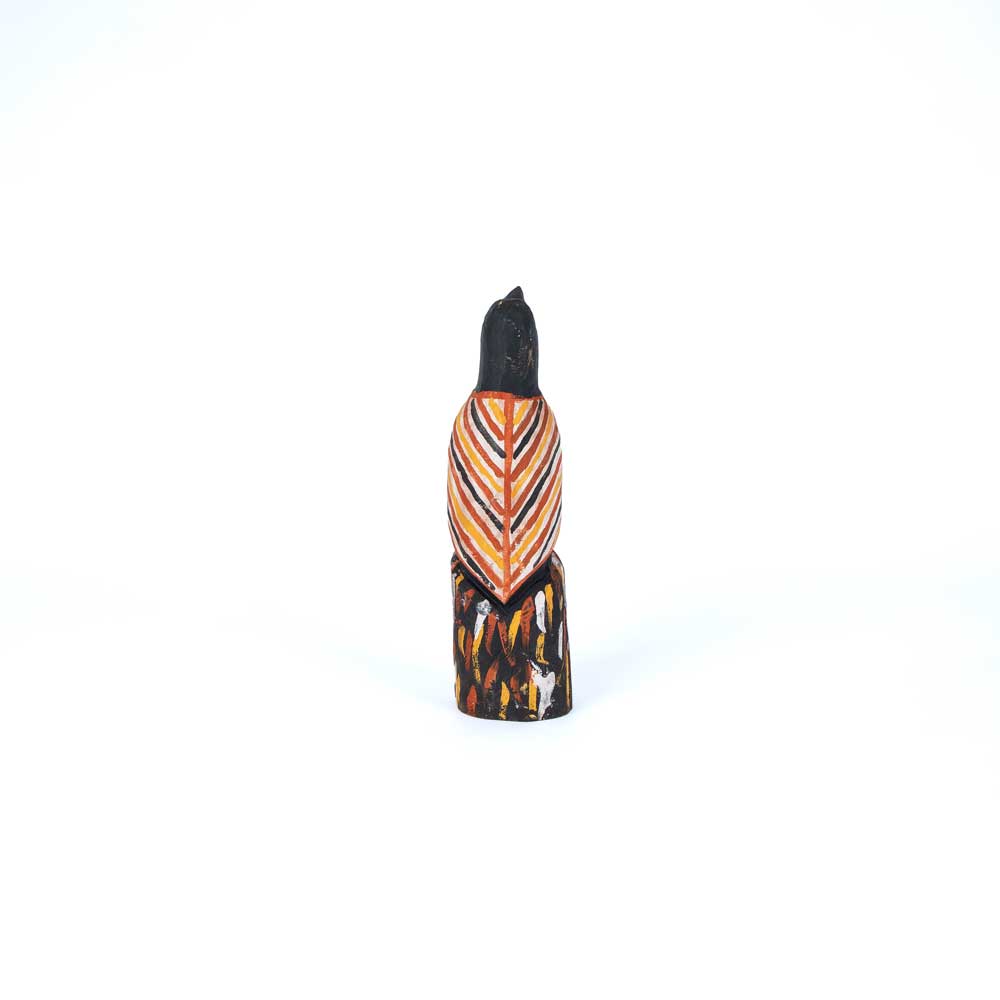 Black Magpie figure, hand carved and painted in the traditional Tiwi Island style, using locally sourced hardwood timber, by artist Albertus Tipiloura on white background