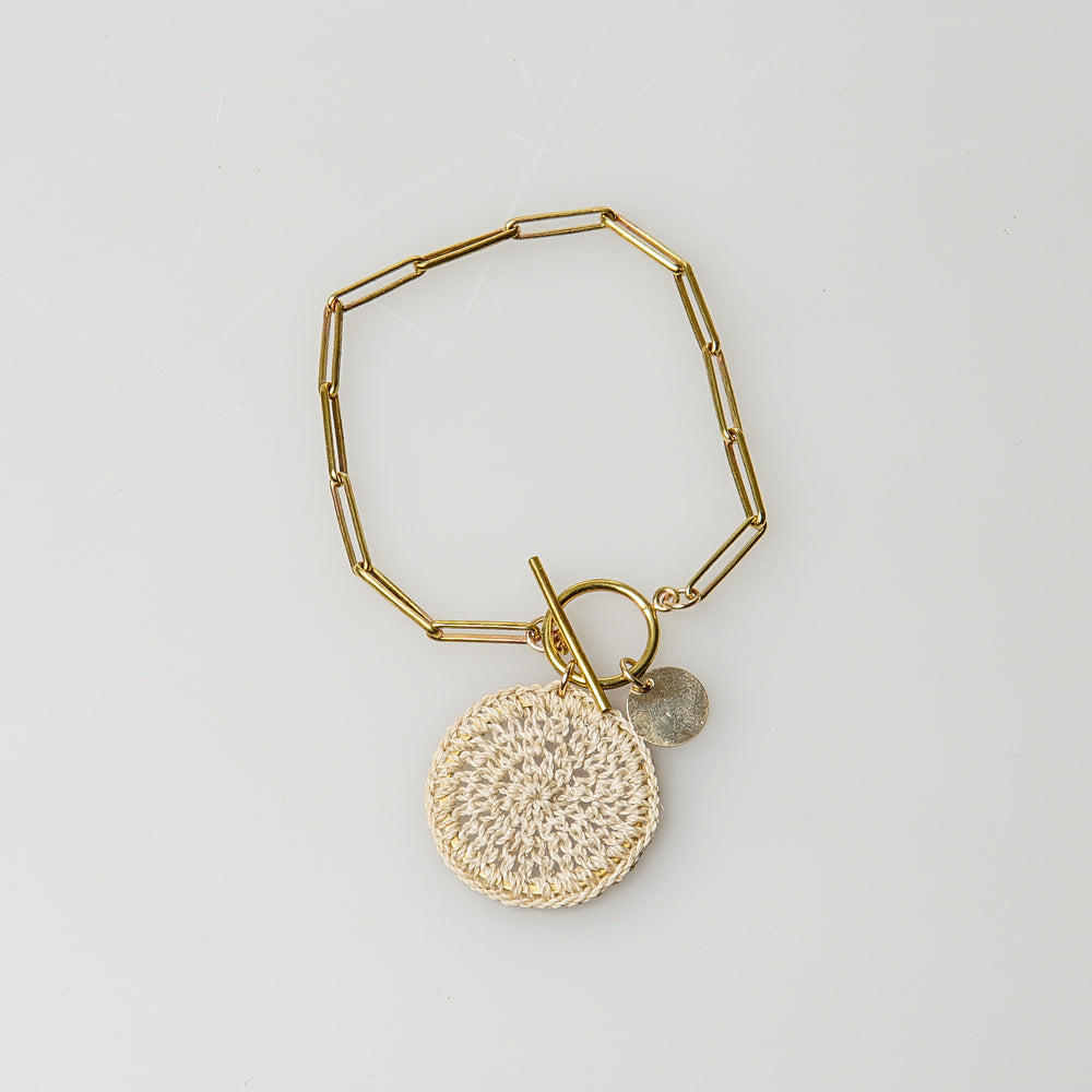 Paperclip raw brass chain bracelet, with T-bar toggle, a gold coin and delicate natural fibre woven disc.